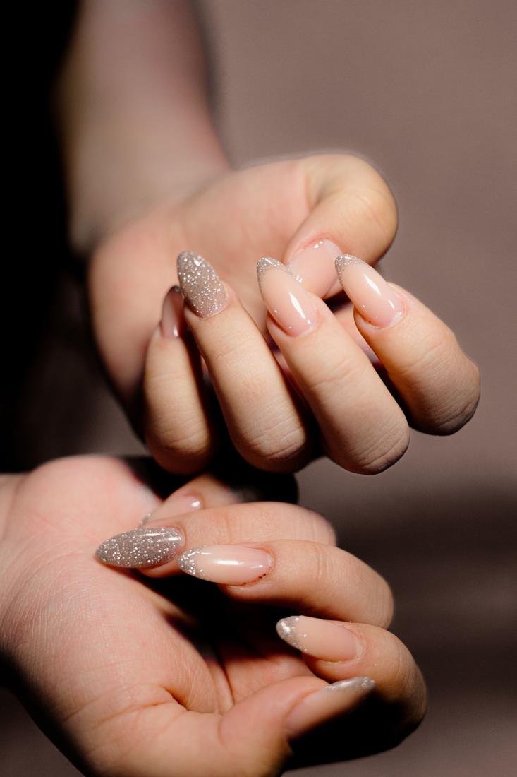 Nude and silver glitter manicure on two hands